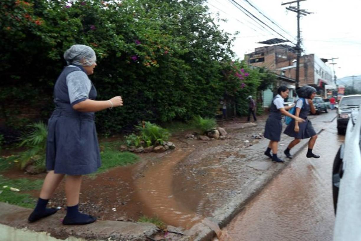 Las lluvias sorprendieron a varias personas como estas estudiantes.