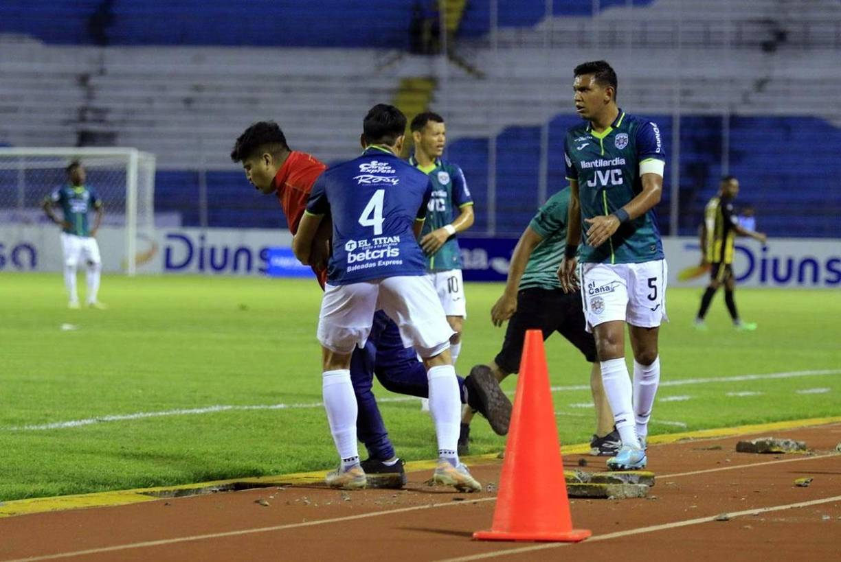 Francisco Martínez tratando de controlar a este otro aficionado en la pista del estadio Olímpico.