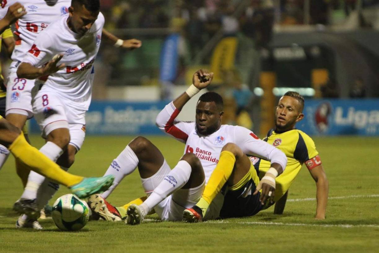 El delantero colombiano Yustin Arboleda disputando el balón desde el suelo.