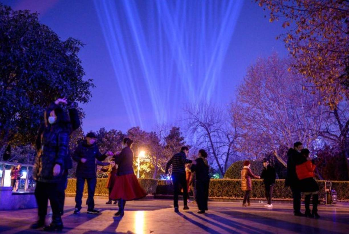 People dance on the banks of Yangtze River on New Year's Eve in Wuhan, in Chinas central Hubei province on December 31, 2020. (Photo by NOEL CELIS / AFP)