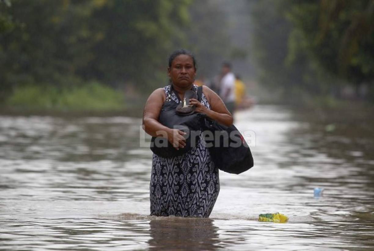Con sus sandalías en mano, este limeña huye de las inundaciones. Hace 20 años que no se reportaban inundaciones.