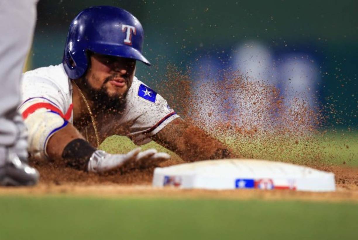El pelotero Rougned Odor, de los Rangers de Texas, se desliza a la tercera base después de golpear un triple contra los Medias Blancas. AFP.<br/>