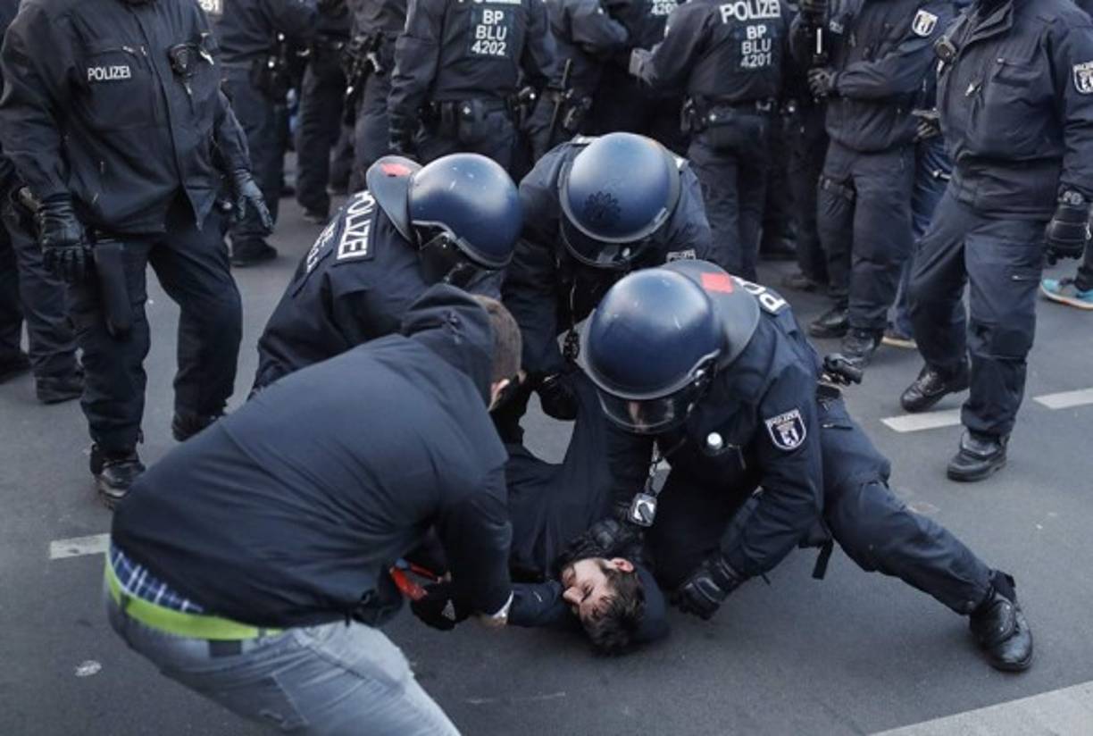 La policía retiene a un participante en la calle en Berlín.