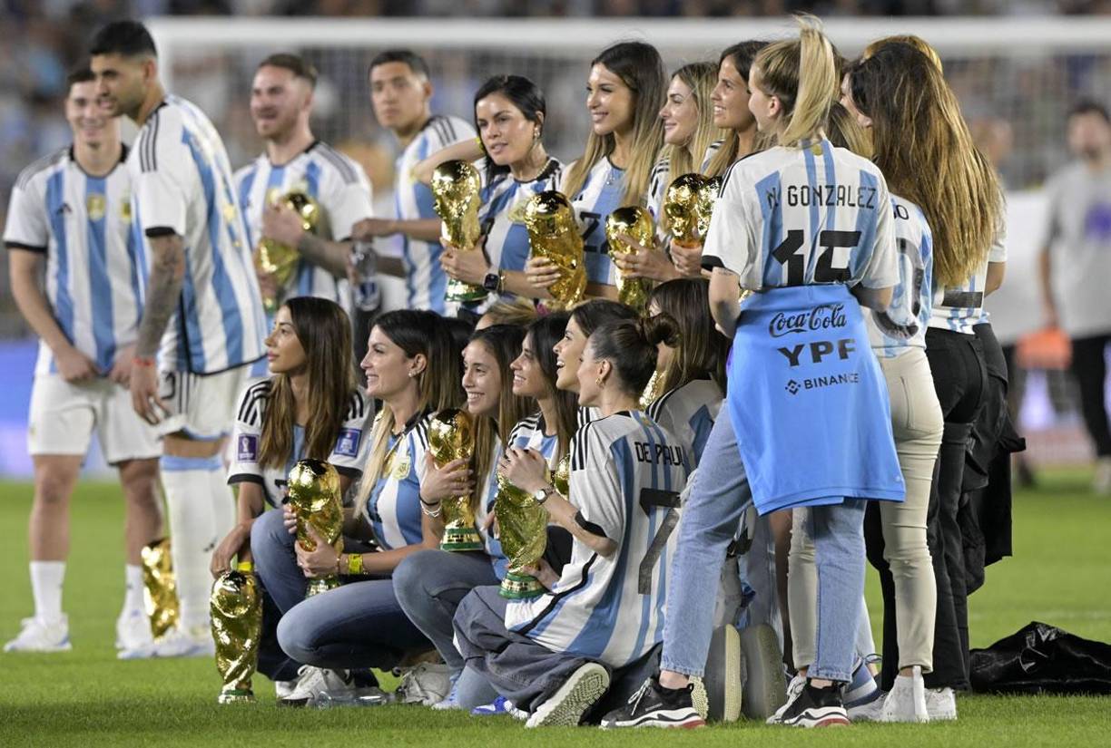 Las novias o esposas de los campeones del mundo posaron con los trofeos.