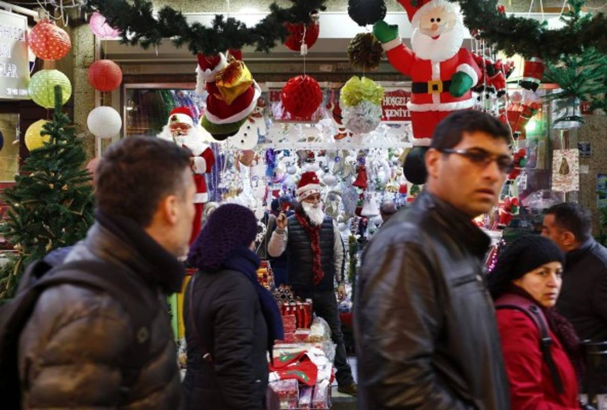 Un vendedor disfrazado de Papa Noel (c) publicita su mercancía en el bazar Tahtakale del barrio de Eminonu en Estambul (Turquía).