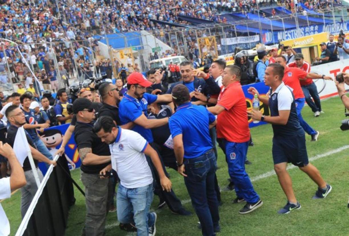 Osman Madrid y otros miembros del Olimpia tratando de impedir que Diego Vázquez ingrese.