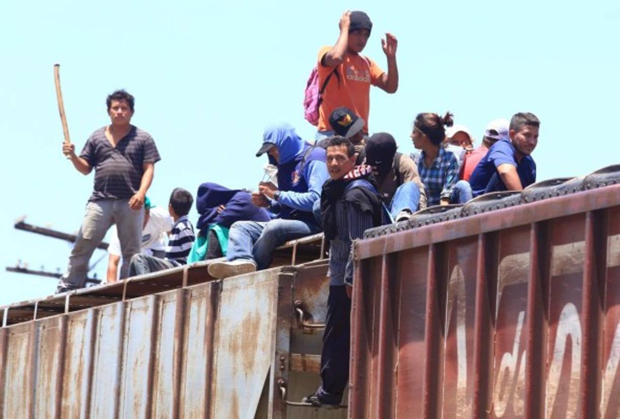 La mayoría de hondureños viajan en el techo del tren y se arman de palo para defenderse de las bandas delincuenciales.