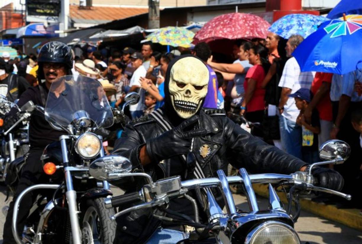 Un hombre en motocicleta hace la señal de amor y paz.