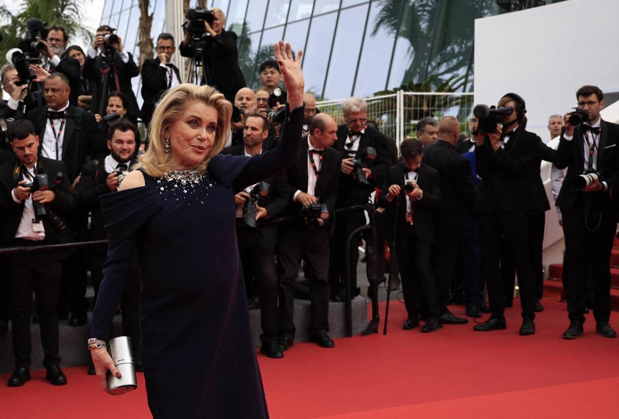 Catherine Deneuve, icono del cine francés y protagonista del cartel de esta edición del festival, eligió un vestido con escote bordado que dejaba sus hombros al descubierto.