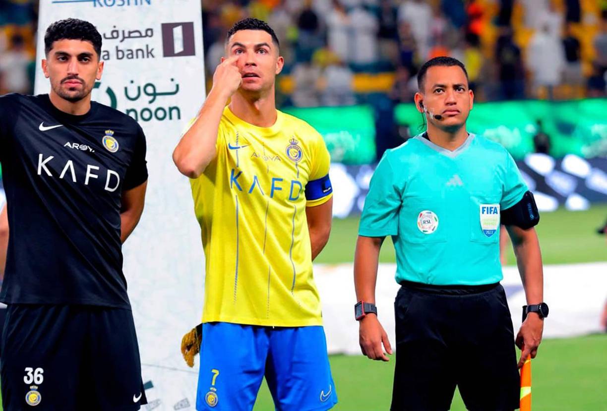El árbitro asistente hondureño Christian Ramírez junto a Cristiano Ronaldo antes del inicio del partido.
