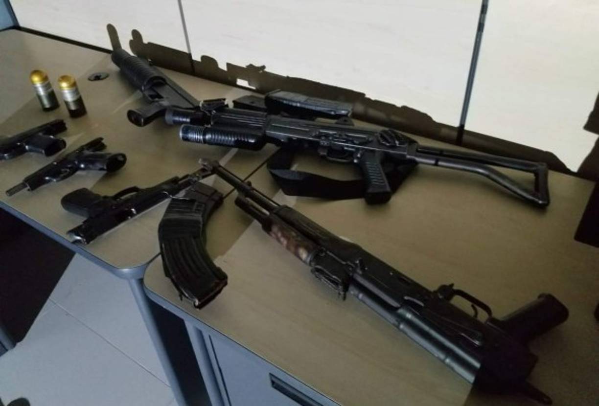 Pistolas, fusiles y cargadores decomisados.