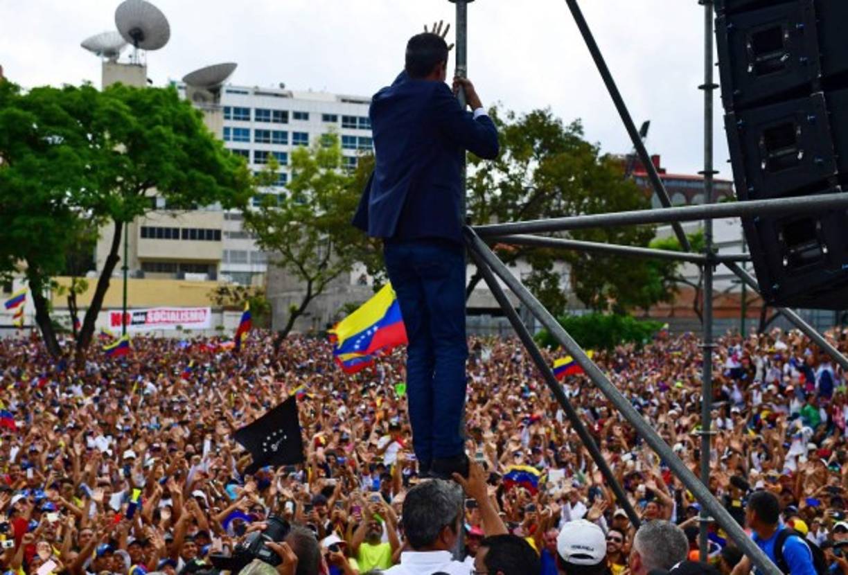 'Aquí está su presidente encargado', lanzó el político con la mano en el pecho, mientras los partidarios, de varias generaciones y a quienes convocó para acompañar su retorno luego de una gira por cinco países suramericanos, se esforzaban por fotografiarlo con sus teléfonos.