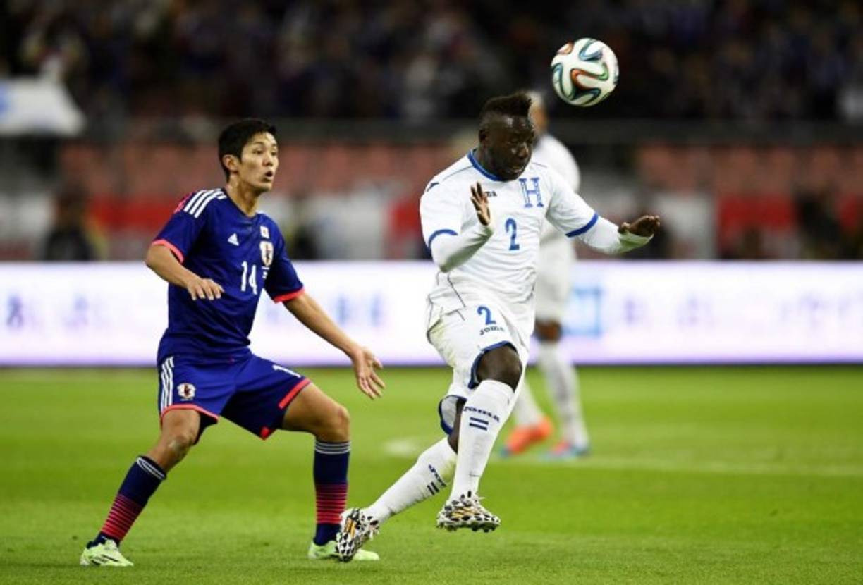 El defensa hondureño Wilmer Crisanto domina de cabeza el balón ante la presión del delantero japonés Yoshinori Muto.