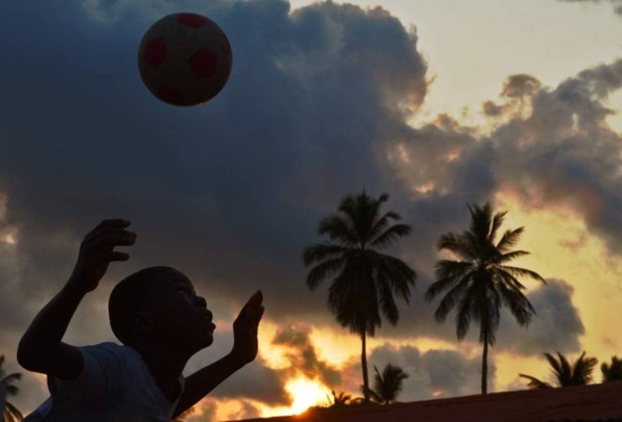 Un niño apurando las horas del día jugando a fubol en Guinea Ecuatorial.