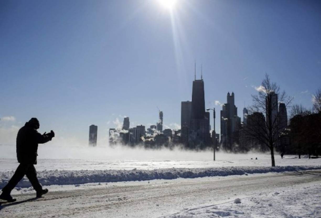 A man takes a photo of Lake Michigan and the skyline as temperatures dropped to -20 degrees F (-29C) on January 30, 2019 in Chicago, Illinois. - Frostbite warnings were issued for parts of the US Midwest on January 30, 2019, as temperatures colder than Antarctica grounded flights, forced schools and businesses to close and disrupted life for tens of millions. (Photo by JOSHUA LOTT / AFP)