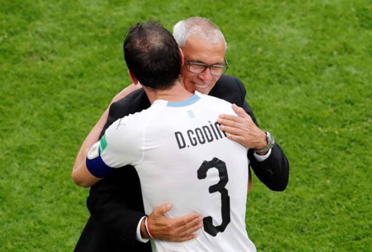 El argentino Héctor Cúper y el uruguayo Diego Godín se saludan en el juego Uruguay-Egipto. Foto EFE