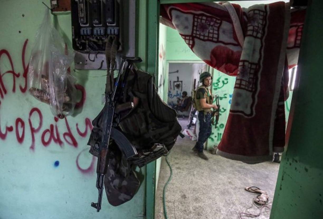 Los miembros de las fuerzas iraquíes están de guardia en una casa en la línea de frente en la antigua ciudad de Mosul.