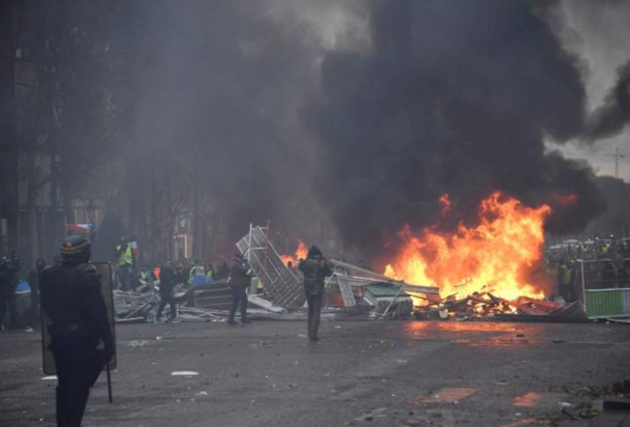 Los bomberos intervinieron para apagar las barricadas incendiadas, de las que salía una espesa humareda negra que se mezclaba con la nube de gases lacrimógenos.