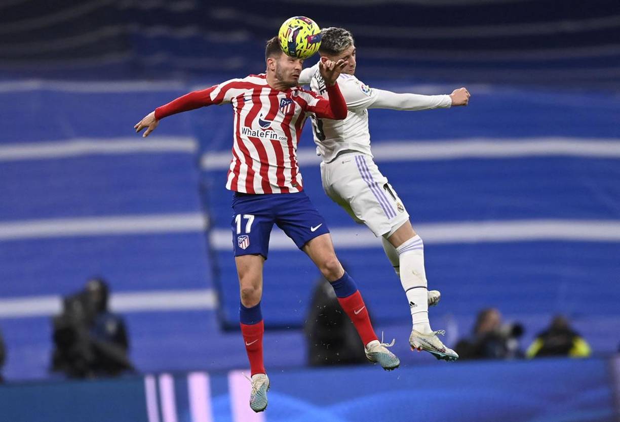 Saúl Ñíguez y Fede Valverde saltando en la disputa por el balón.
