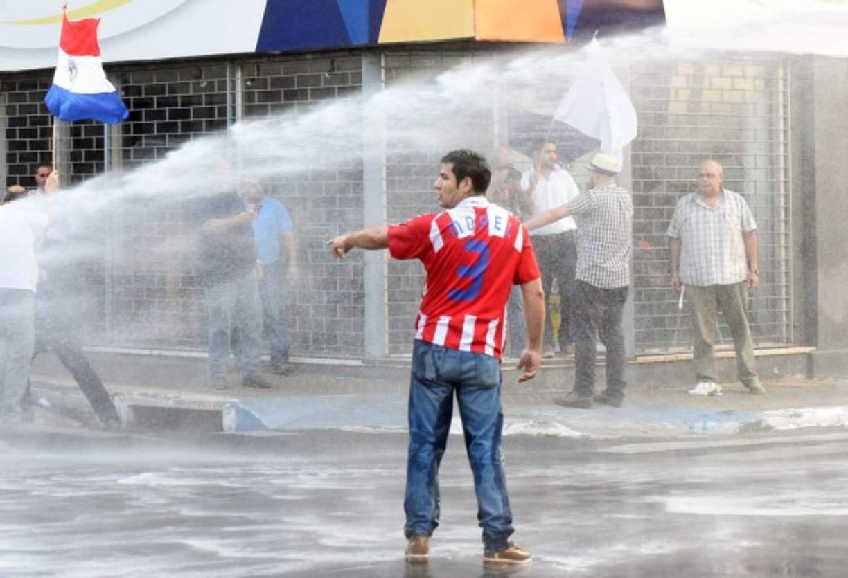 Agentes antidisturbios que acordonan el edificio, en el centro de Asunción, dispararon balines de goma a manifestantes.<br/>