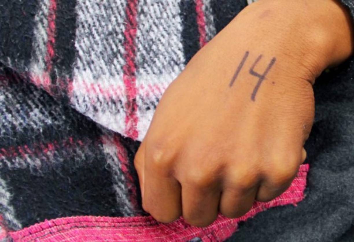 Cada día, un agente de la CBP sale de la garita con un cuaderno para anotar un máximo de 20 personas que serán atendidas para petición de asilo. El resto de migrantes esperan varios días hasta que llegue su turno.