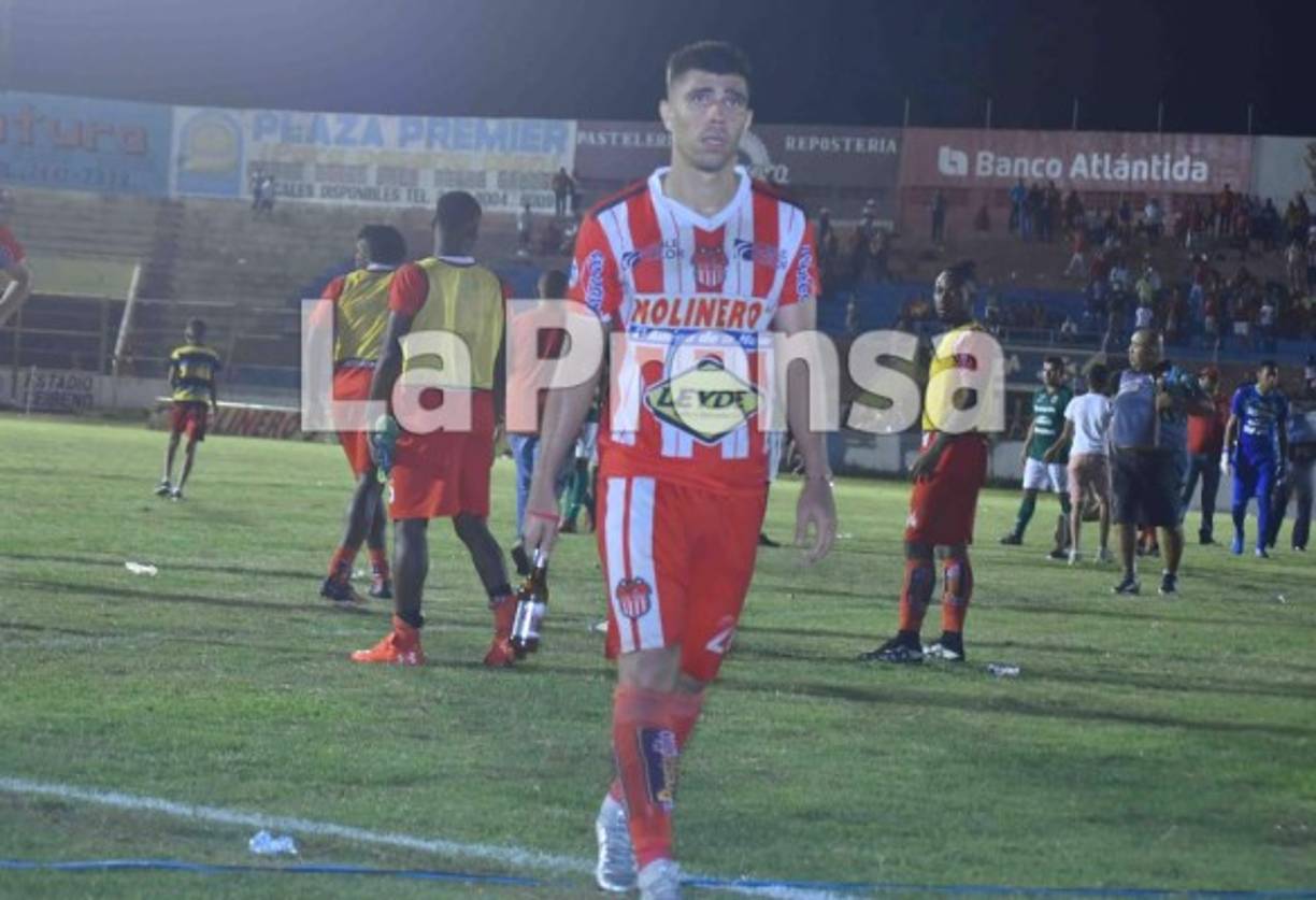 El jugador cocotero Marcelo Santos saca del campo una botella de cerveza.