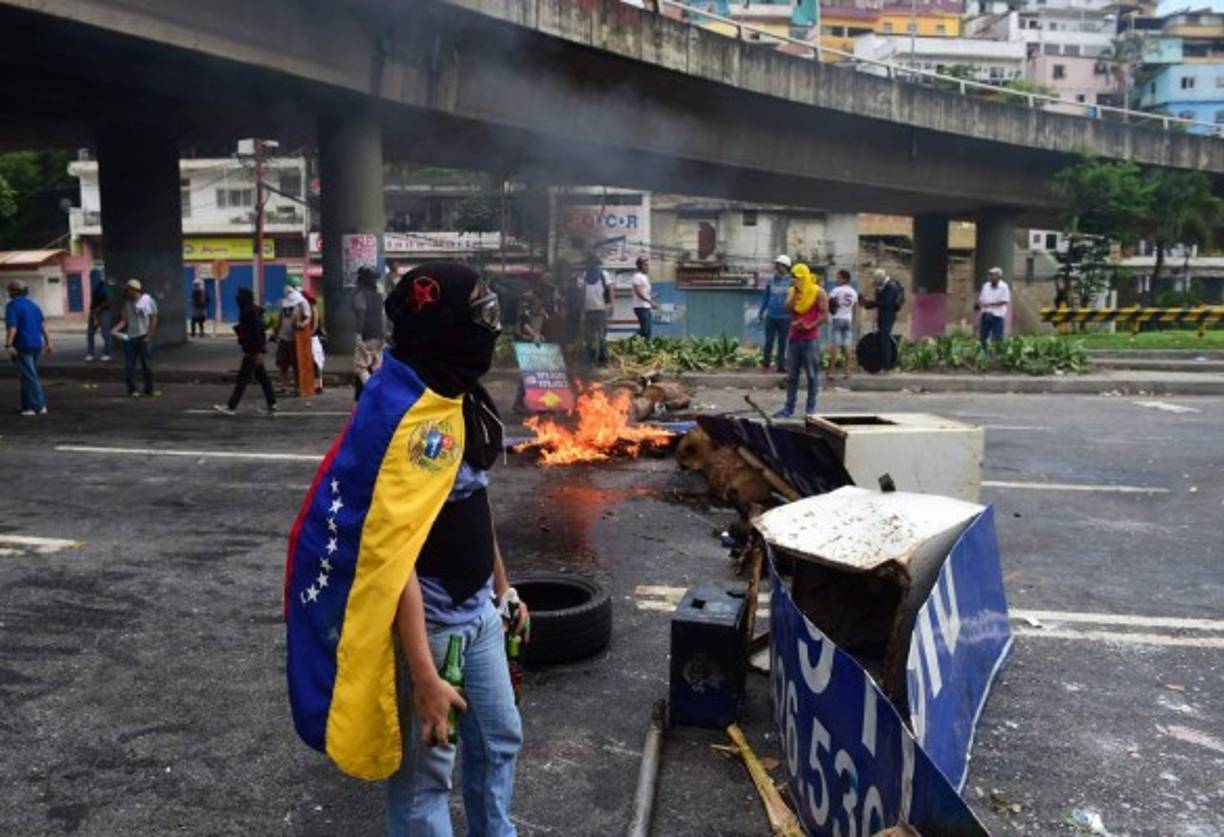 Anti-government activists set up barricades during a protest against the elections for a Constituent Assembly in Caracas on July 30, 2017.<br/>Deadly violence erupted around the controversial vote, with a candidate to the all-powerful body being elected shot dead and troops firing weapons to clear protesters in Caracas and elsewhere. / AFP PHOTO / RONALDO SCHEMIDT