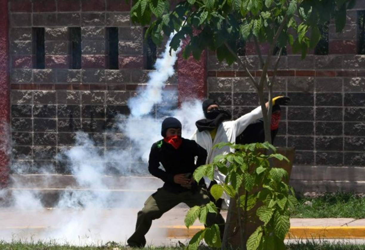Los estudiantes encapuchados del Movimiento Estudiantil Universitario (MEU) se enfrentaron con la policía en el bulevar Suyapa de Tegucigalpa. AFP