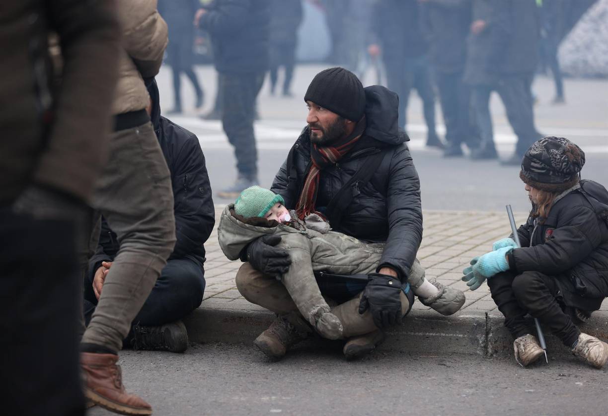 Entre 2.000 y 3.000 personas, incluidas mujeres y niños, acampan desde hace varios días bajo un frío glacial en la frontera entre estos dos países. Intentan entrar en calor apiñándose alrededor de fogatas o envueltos en mantas.
