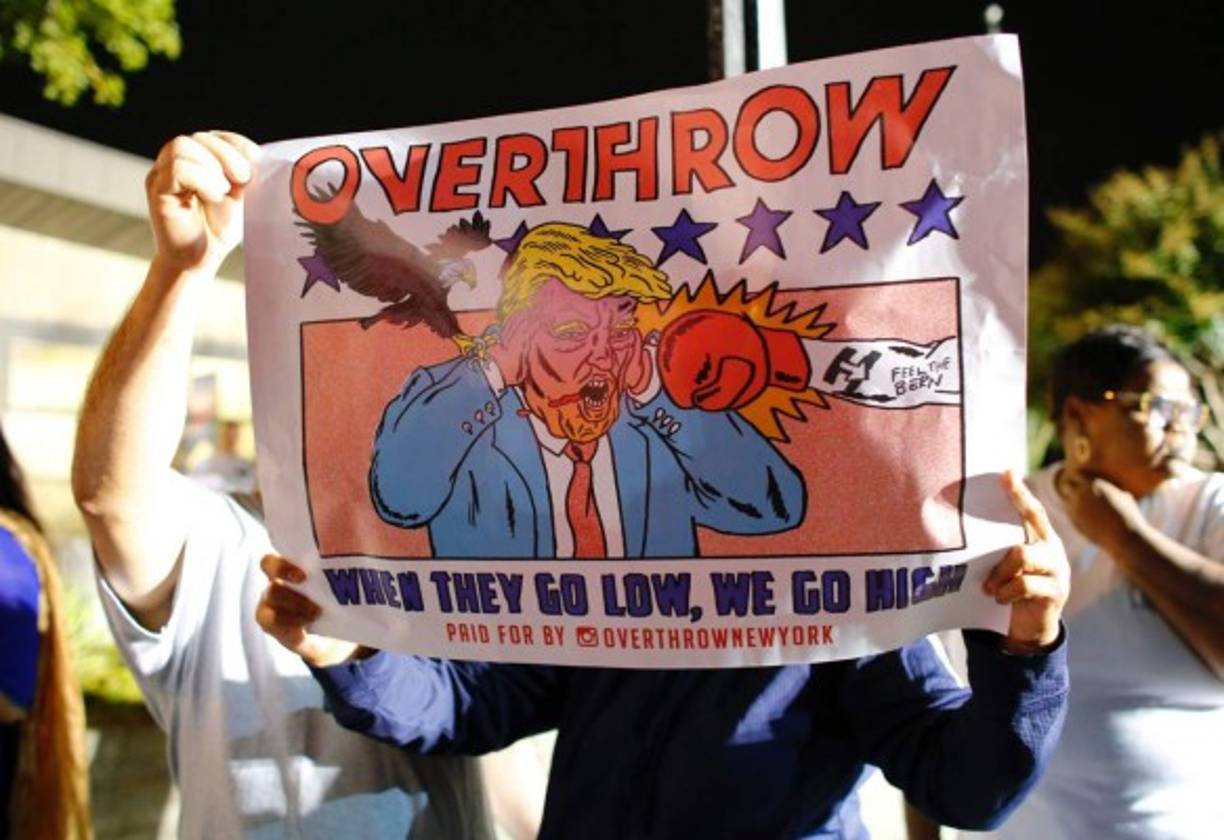 Un Trump caricaturizado es el protagonista de la pancarta que muestra este manifestante.