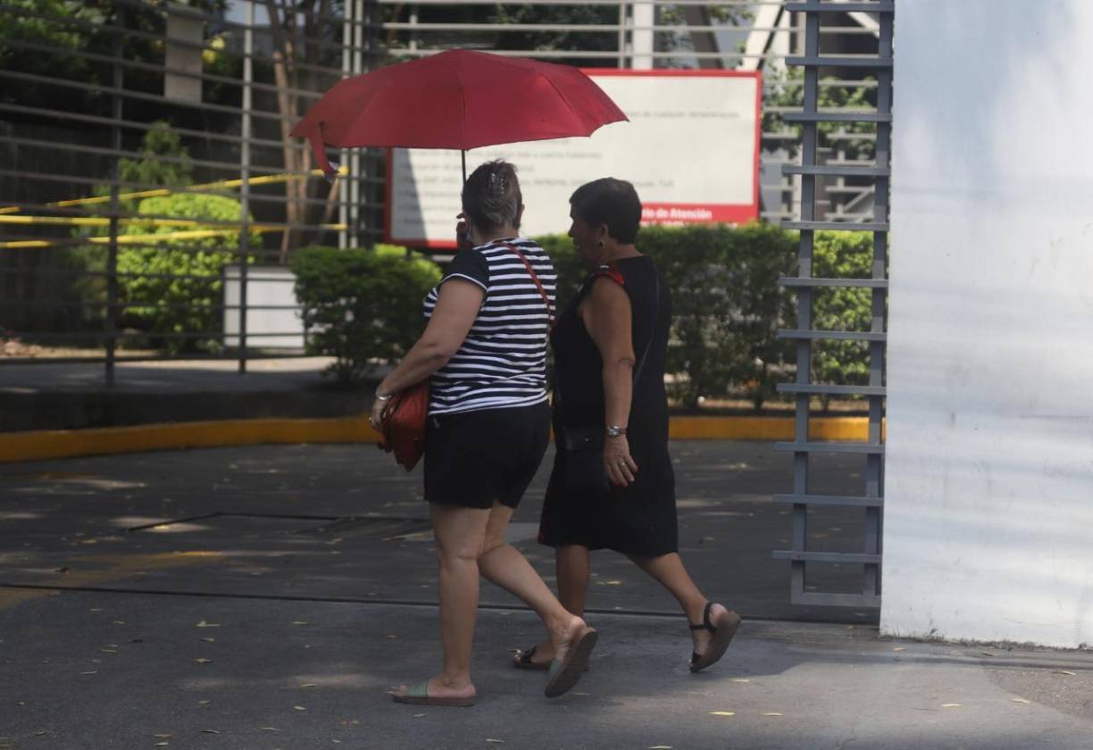 Ellas compartieron el paraguas para no perderse lo amena que estaba la plática.