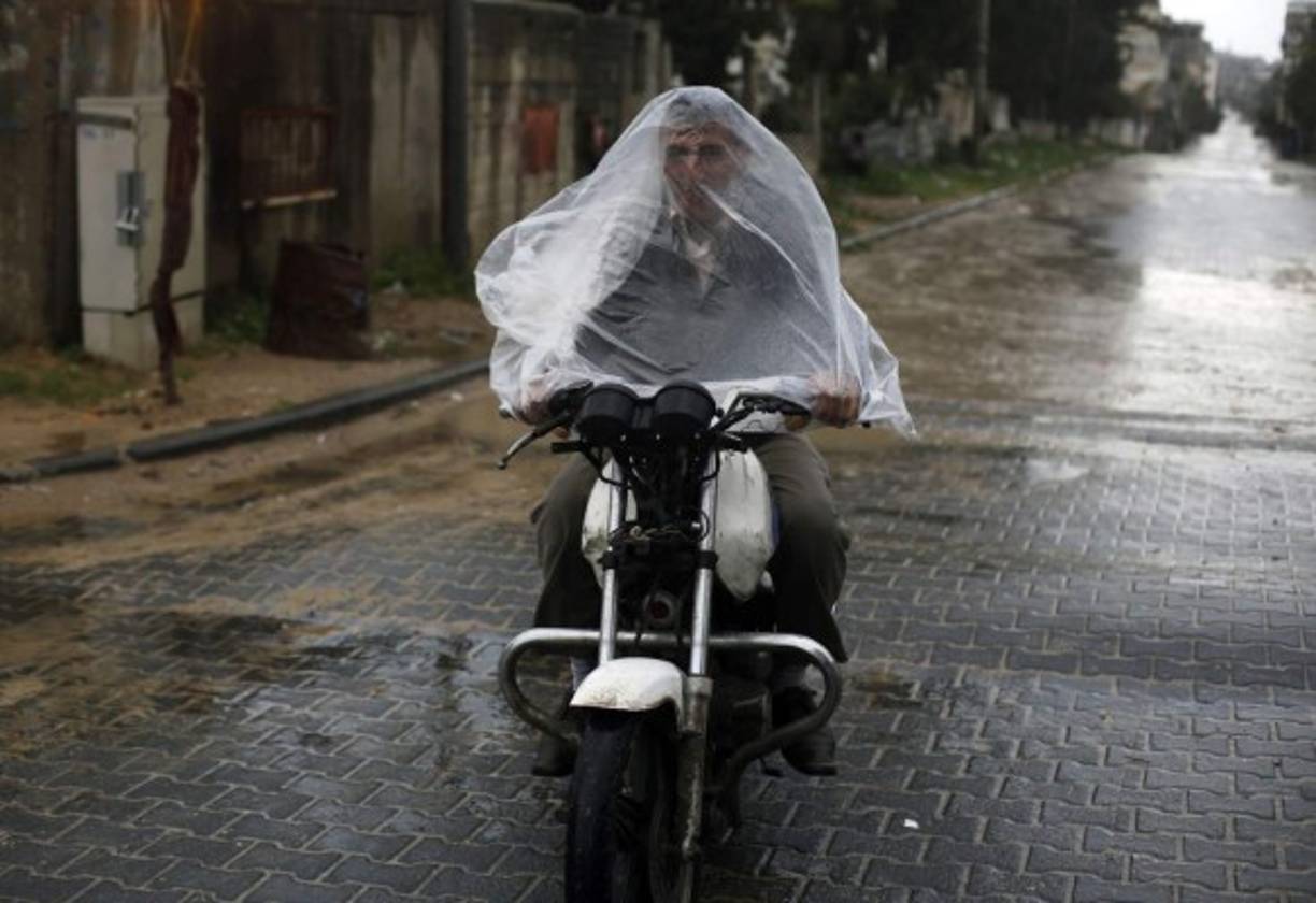 Un palestino se resguarda de la lluvia como buenamente puede.
