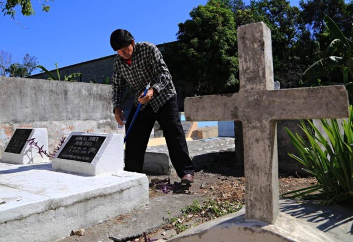 Barrer los caminos entre las tumbas es otra labor que se realiza con motivo del Día de los Muertos.