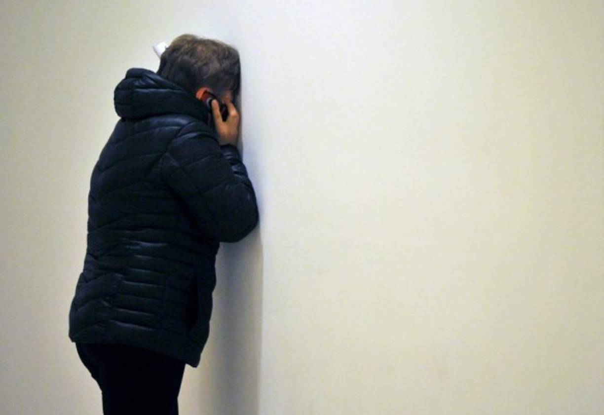 Contra la pared y con el teléfono en el oído, un pariente de las víctimas demuestra su dolor tras conocer del accidente del avión con 224 personas en Egipto.