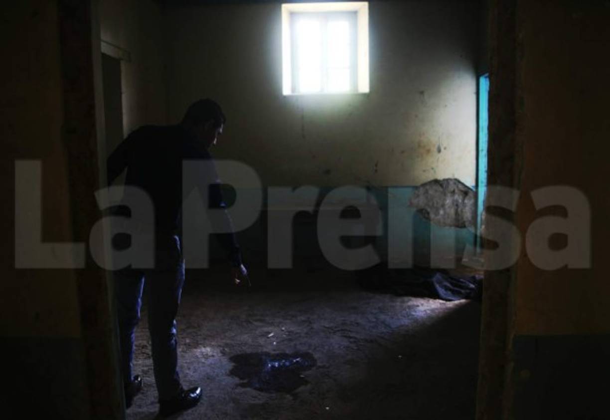 Enfrente de la mujer había una cruz de madera y en una pared un grafiti en el que se podía leer “pacto 2018”.