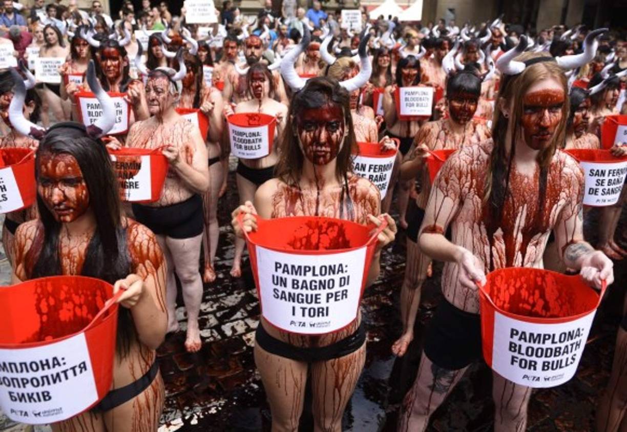 ESPAÑA. Dicen no al maltrato de los toros. Activistas semidesnudos y con diademas con cuernos bañados con sangre artificial para escenificar, en la Plaza del Ayuntamiento de Pamplona. Fotos: EFE