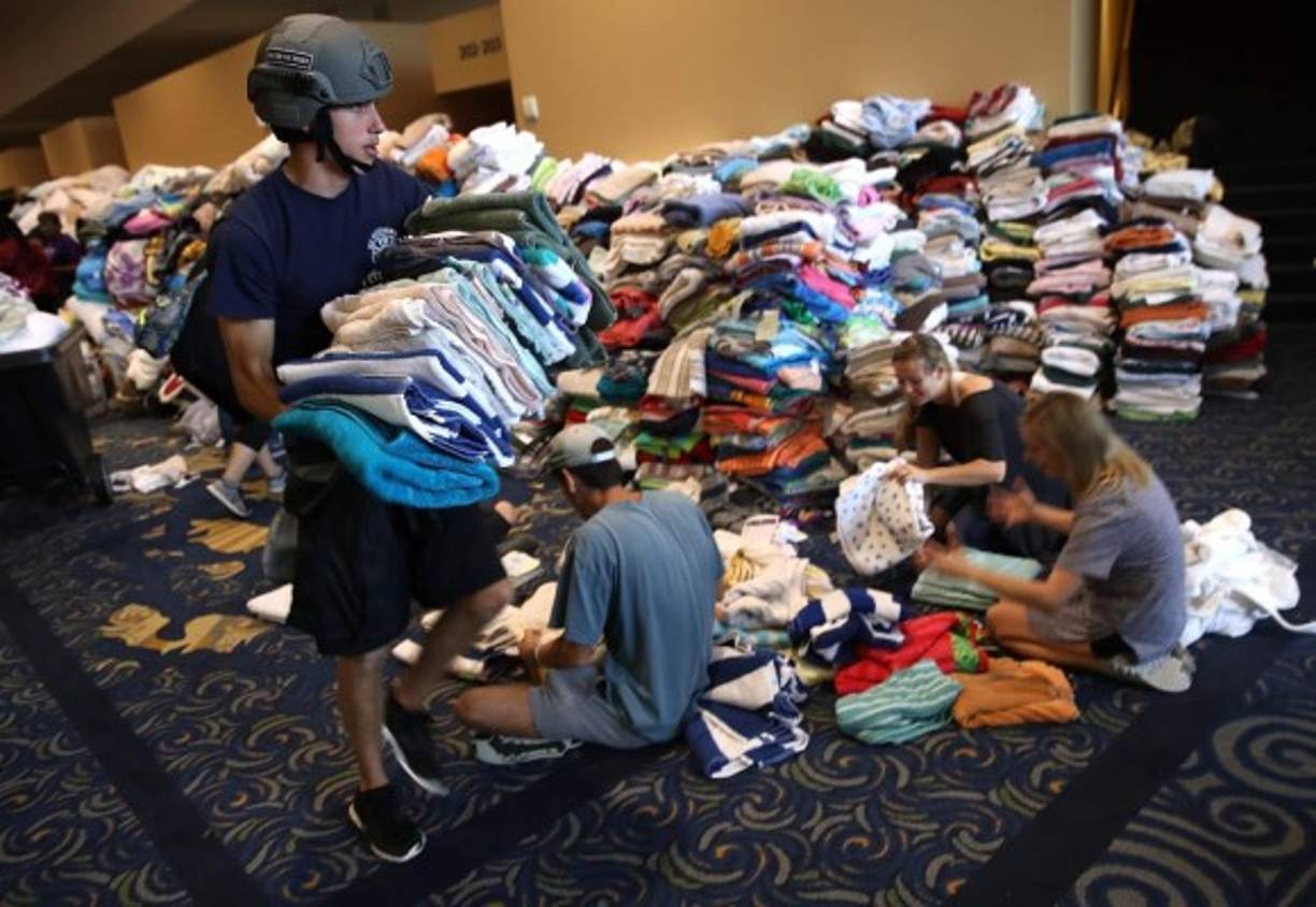 De inmediato comenzaron a llegar autobuses llenos de personas afectadas por las inundaciones. Decenas de voluntarios se alistaron para repartir ropa y sábanas a los damnificados.