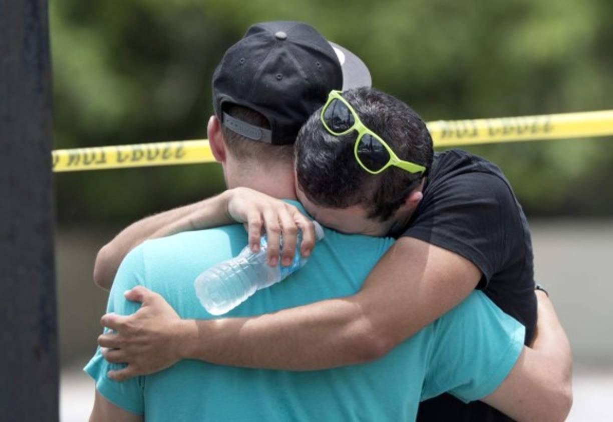 Amigos y familiares de los fallecidos se consuelan frente al cuartel general de la policía de Orlando.