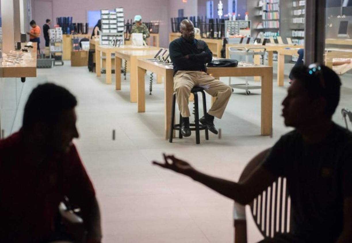 Los compradores conversan frente a una tienda mientras esperan la hora de apertura en Washington, Estados Unidos.