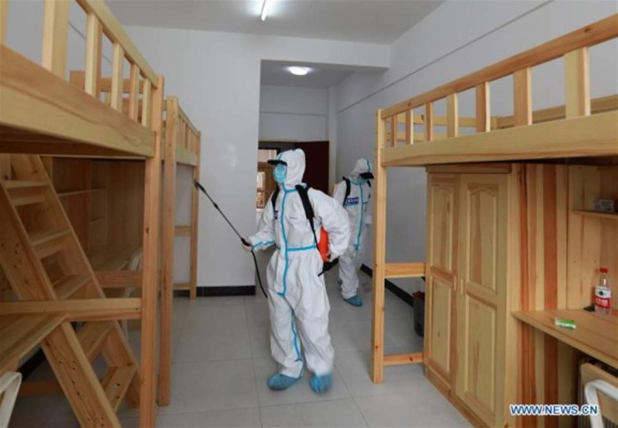 Personal de salud realizando la desinfección en el dormitorio de los estudiantes de último año de la Escuela Secundaria N ° 23 en Wuhan, provincia de Hubei, en el centro de China.