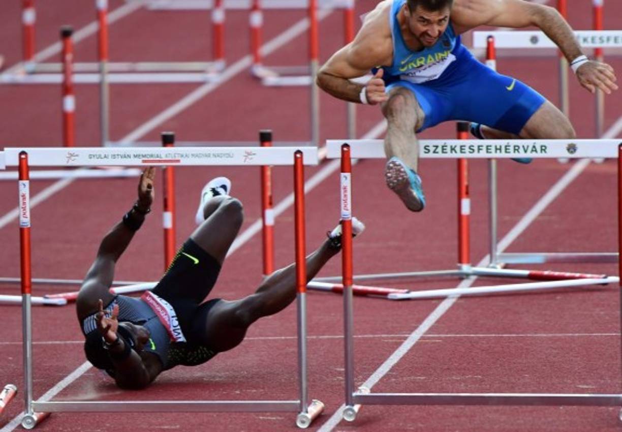 ATLETISMO. Un jamaiquino en apuros. Omar Mcleod (izquierda), de Jamaica, cae junto a Serhiy Kopanayko, de Ucrania, durante los 100 metros vallas finales en el Gran Premio de Hungría que se disputó en el centro deportivo de Szekesfehervar. Es la segunda vez que el jamaiquino sufre una caída. Foto: AFP/Attila Kisbenedek