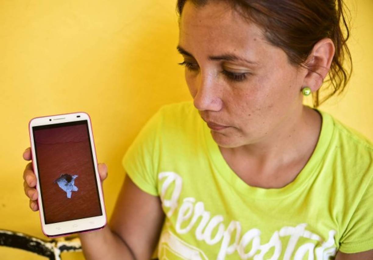 Una mujer muestra como una bala impacto en su dispositivo móvil luego de que los fuertes operativos que ha implementado la Marina en Durango y la inseguridad han hecho que más de 600 personas se hayan desplazado a Sinaloa.