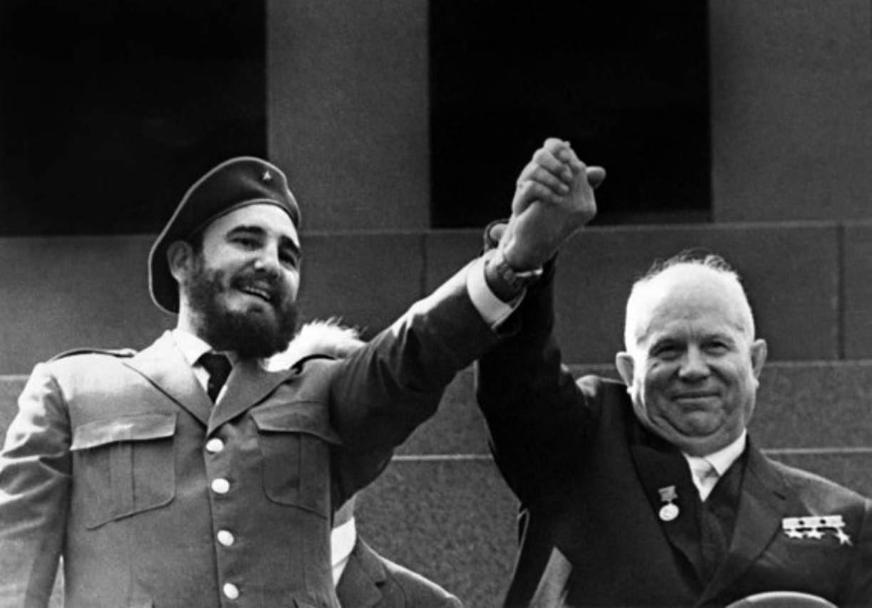 Los mandatarios soviético y cubano, Nikita Khruschev (d.) y Fidel Castro, sonríen mientras levantan sus brazos cogidos de la mano.