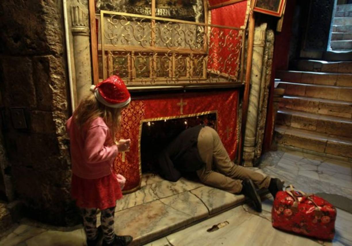 Un papá termina de revisar la chimenea para la llegada de Santa Claus.