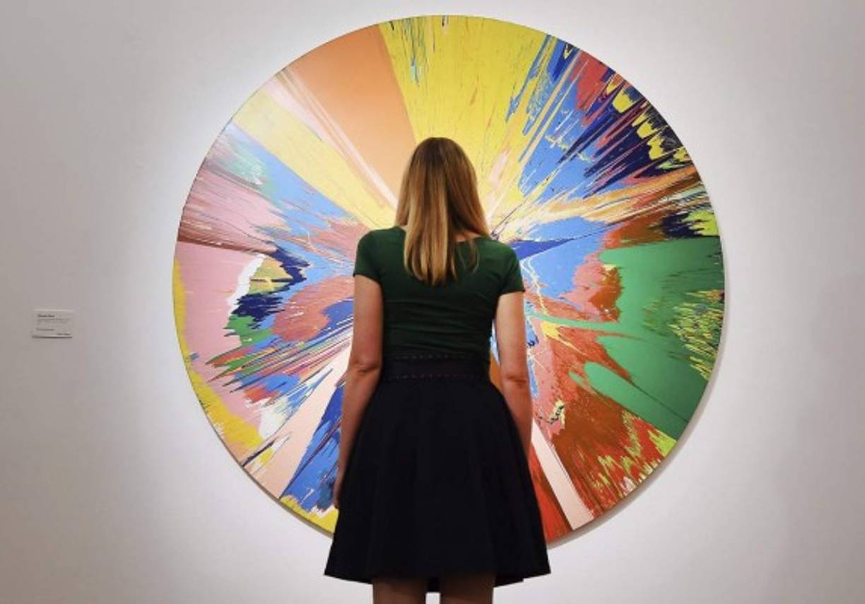 ARTE. Colección de arte de Bowie. Una dama mira una pintura giratoria de Damien Hirst que pertenece a la colección privada David Bowie. Fotos: EFE