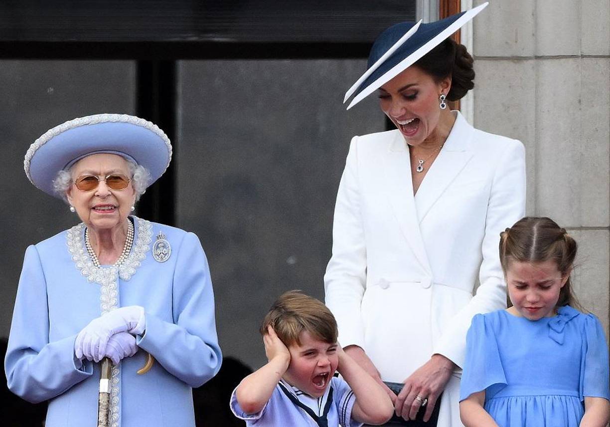 Kate, duquesa de Cambridge de Gran Bretaña reacciona cuando el príncipe Louis de Cambridge se tapa los oídos, mientras están en el balcón con la reina Isabel II y la princesa Charlotte. 