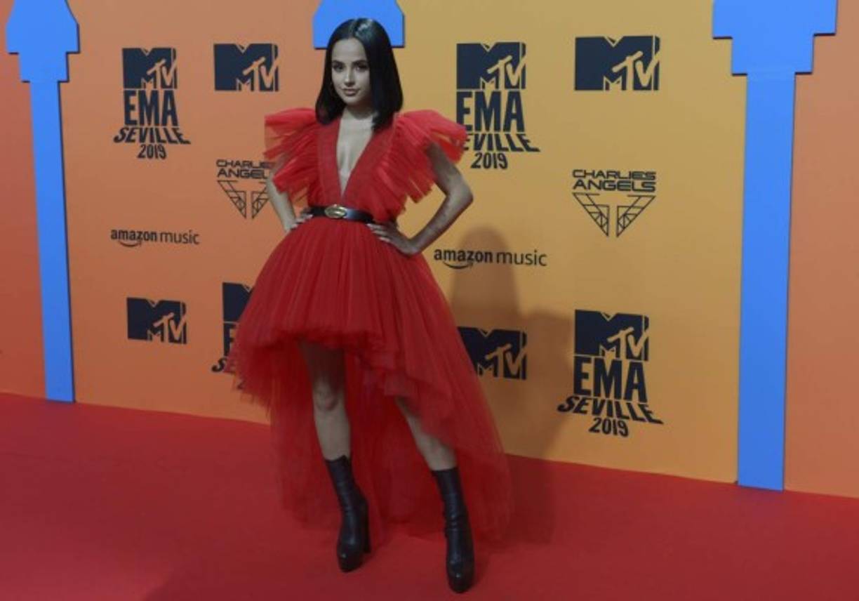 La reguetonera Becky G posó en un vestido de tul rojo que acompañó con unas botas altas.