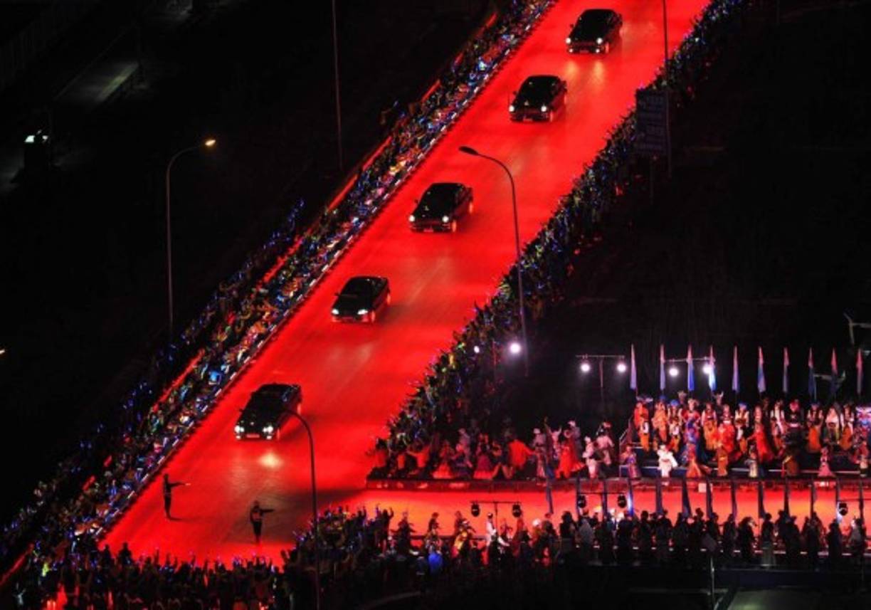 Los presidentes, en lugar de una alfombra roja, fueron recibidos con una calzada para limosinas iluminada eléctricamente de color escarlata, en pleno centro del barrio olímpico.