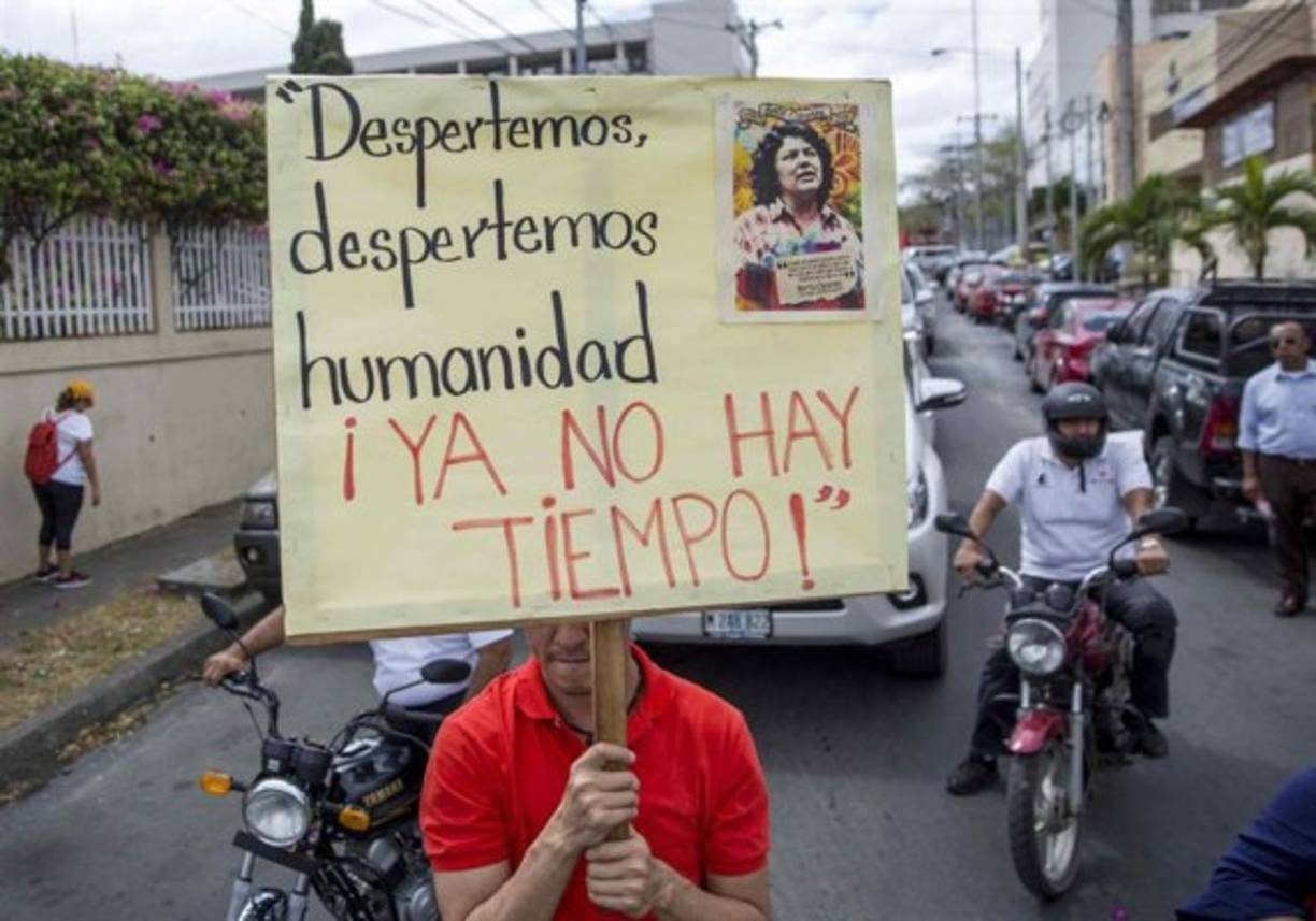 Un hombre sostiene un cartel en honor a la ambientalista hondureña Berta Cáceres durante un plantón en los alrededores de la embajada de Honduras en Nicaragua, en Managua (Nicaragua). Representantes de grupos ambientalistas y feministas realizaron hoy un plantón en Nicaragua para demandar justicia para la líder indígena hondureña Berta Cáceres, asesinada a balazos en su vivienda el 3 de marzo de 2016, sin que hasta ahora el caso haya sido esclarecido. EFE/Jorge Torres.