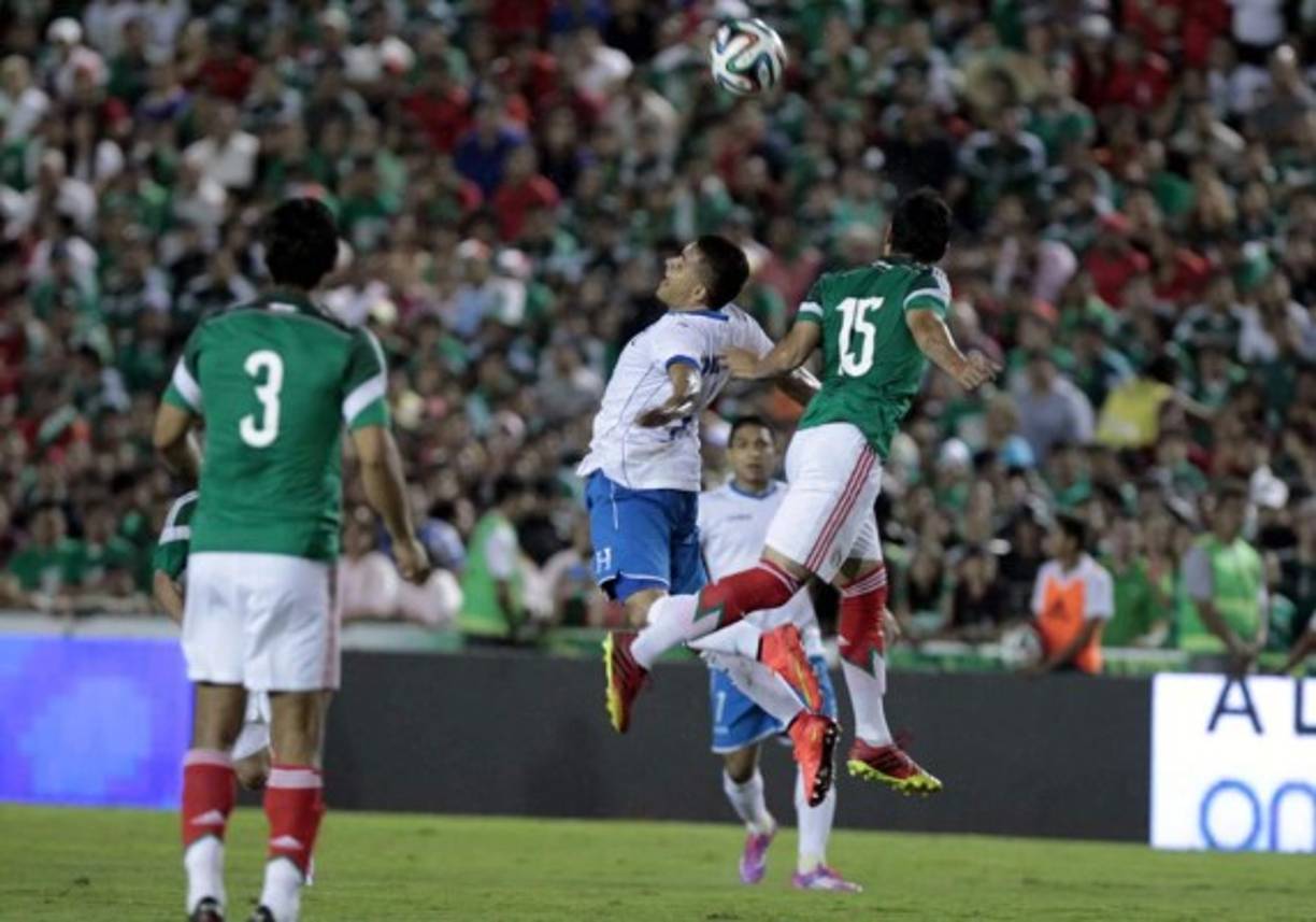 Roger Rojas salta por el balón con Julio César Domínguez.